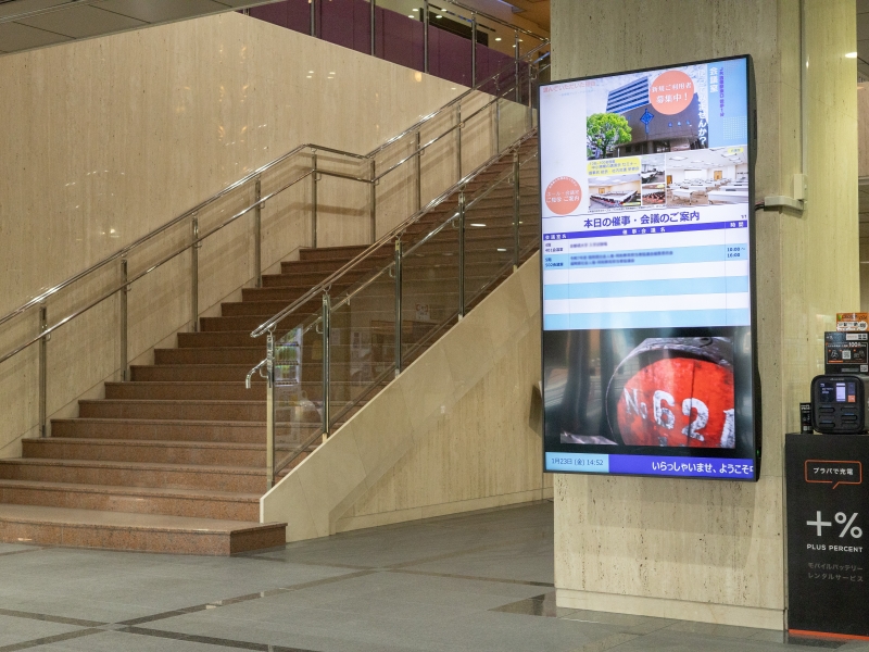 1階エントランス。85インチの縦型サイネージで施設案内や地域情報を表示